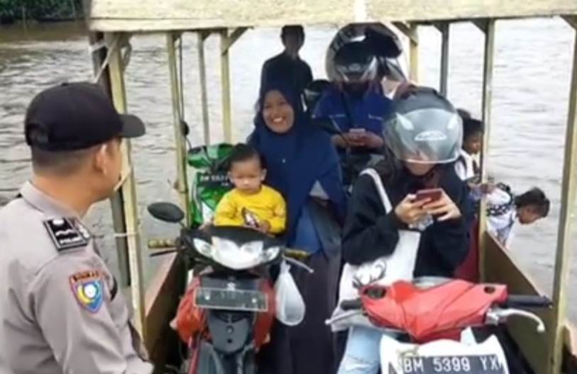 Personel Polres Siak bersama warga di atas sampan.(foto: istimewa)